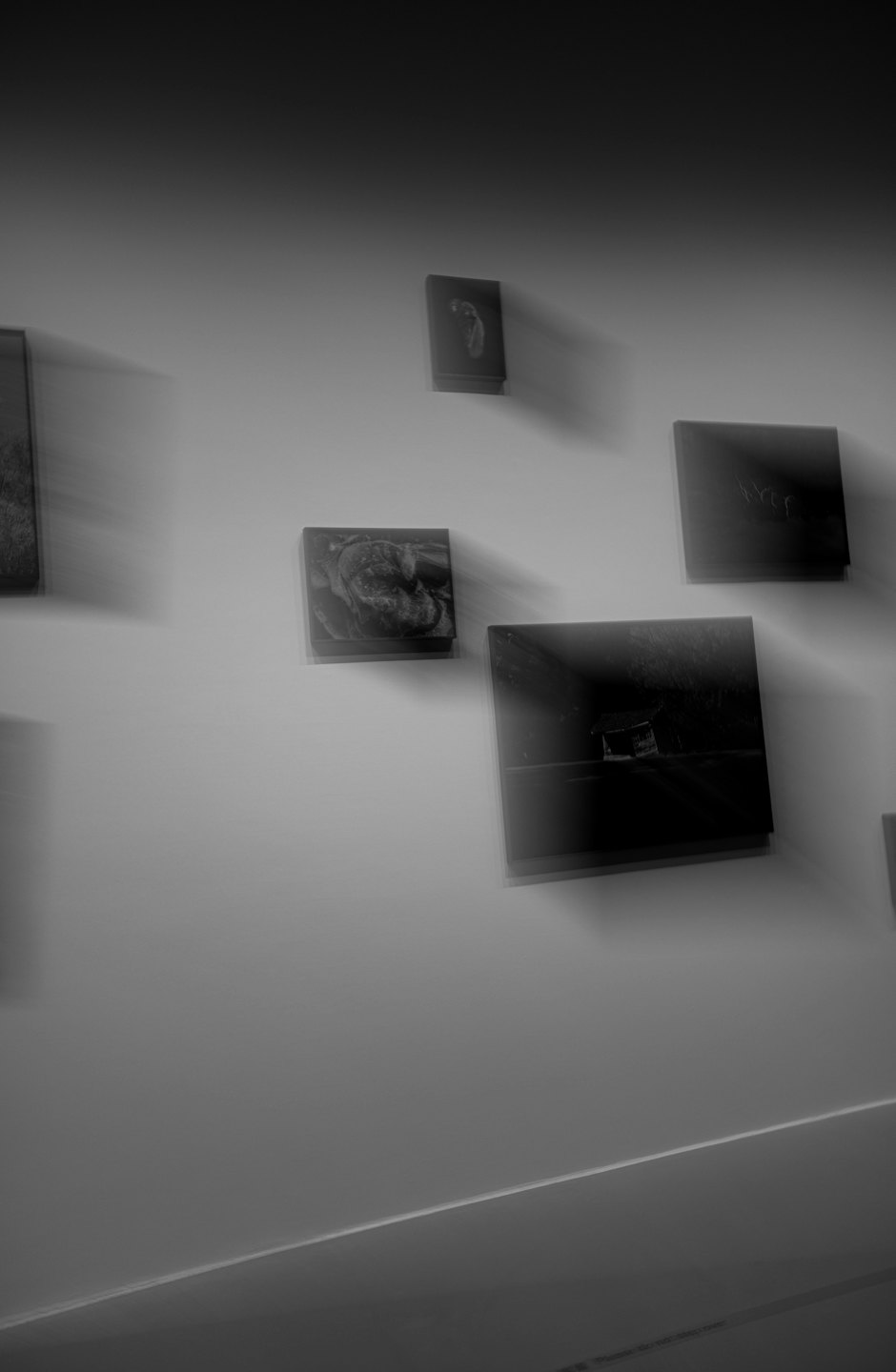 Framed photographs hang on a gallery wall.